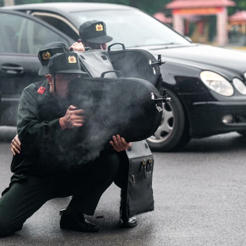 가방에 보관된 AKMS를 은닉 사격 하는 베트남 공안부 경찰관